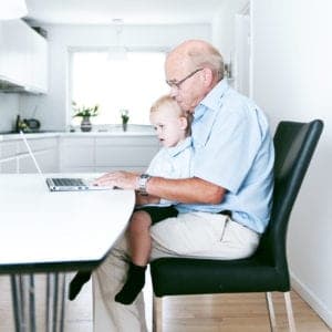 Un abuelo y su nieto miran un ordenador disfrutando de unos buenos momentos en familia viendo el blog de una clínica que ha contratado su Web, móvil y contenidos digitales a Medicalta, marketing sanitario para clínicas y clínicas dentales.