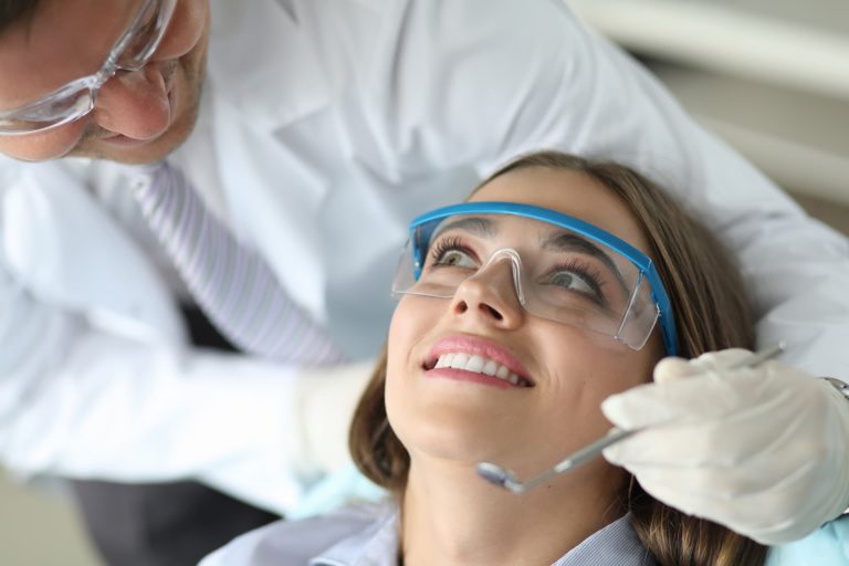 Una paciente está en el sillón de un dentista esperando empezar el tratamiento gratuito