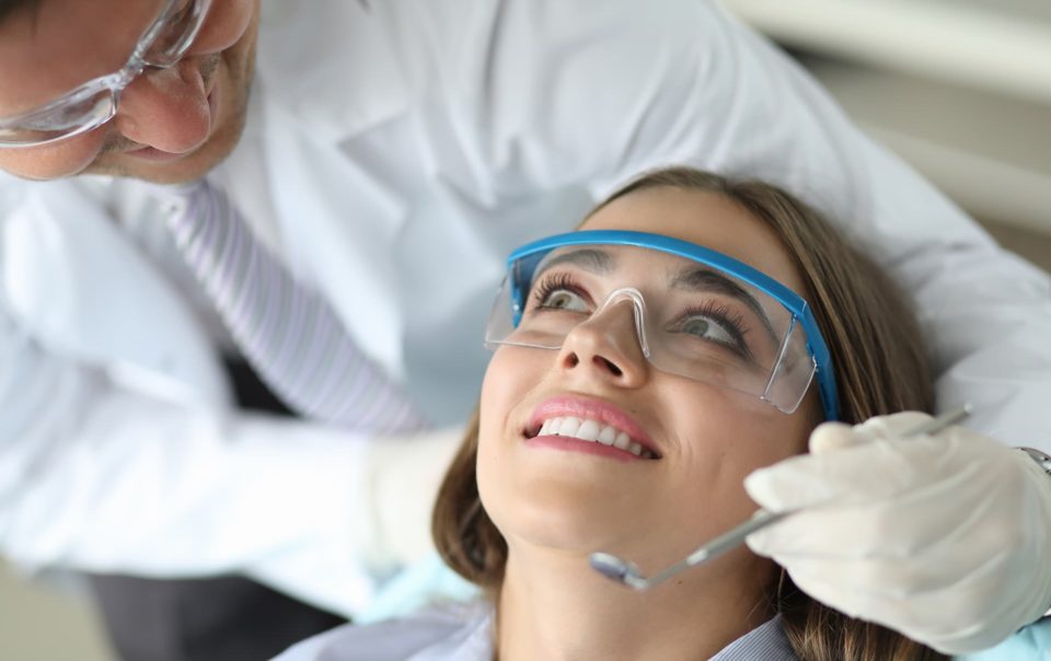 Una paciente está en el sillón de un dentista esperando empezar el tratamiento gratuito